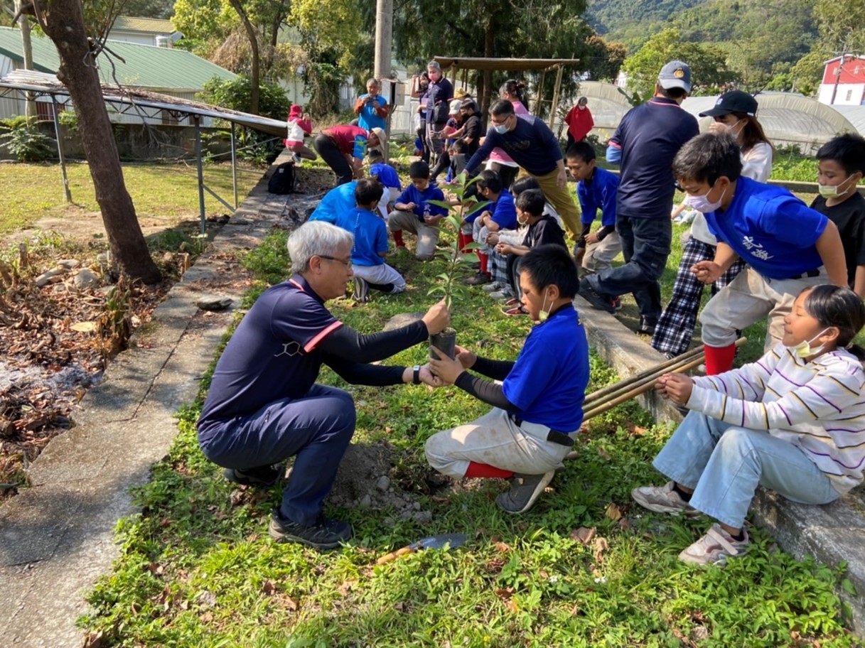 校長、部落主席、村長及主任帶領學童種樹，落實綠色生活。